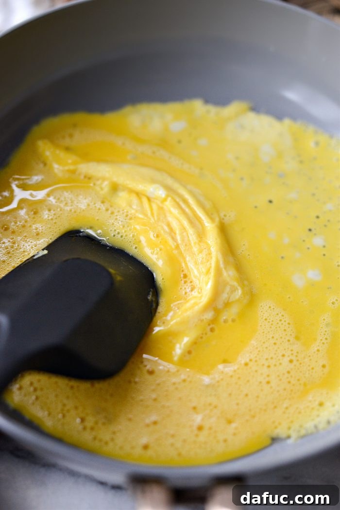 Creamy Cottage Scrambled Eggs 8 Adding eggs to a pan and gently stirring until scrambled