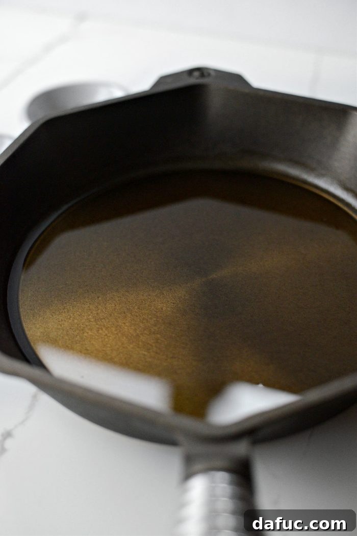 Adding avocado oil to a hot cast iron skillet