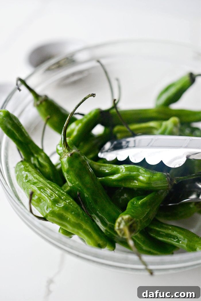 Tossing shishito peppers to ensure an even coating of oil