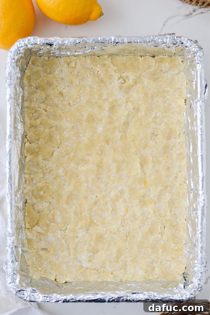 Pressing the shortbread dough into an even layer in the bottom of the pan