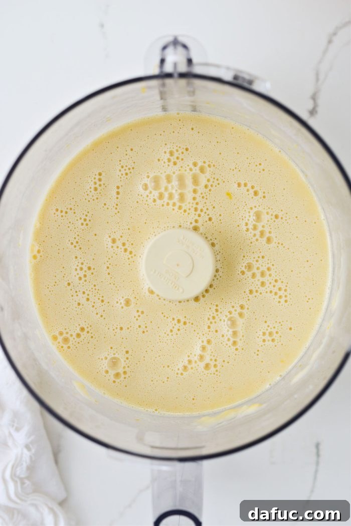 Food processor blending the lemon filling after adding eggs