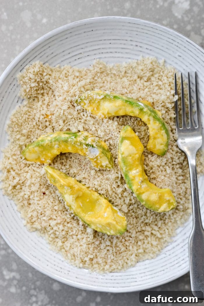 Coating avocado wedges in seasoned panko breadcrumbs