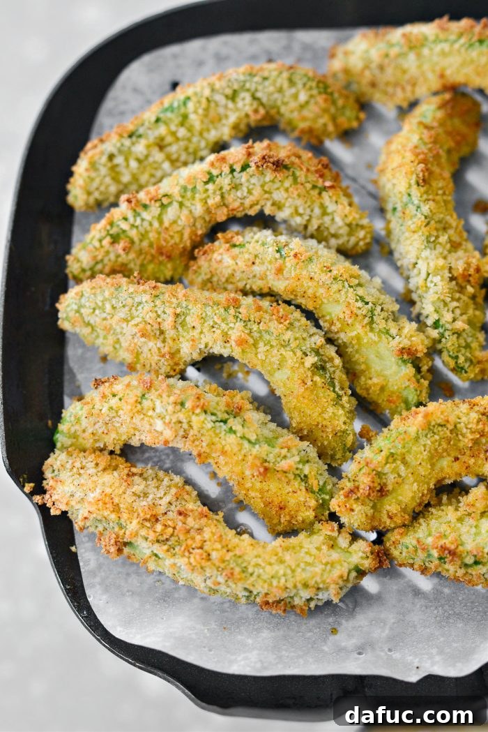 Crispy golden air fried avocado fries on a tray