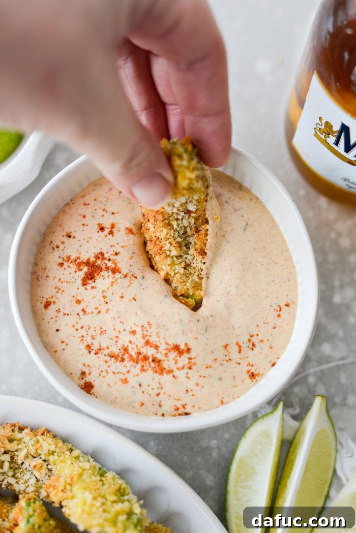 Avocado fries being dipped in Southwest Ranch