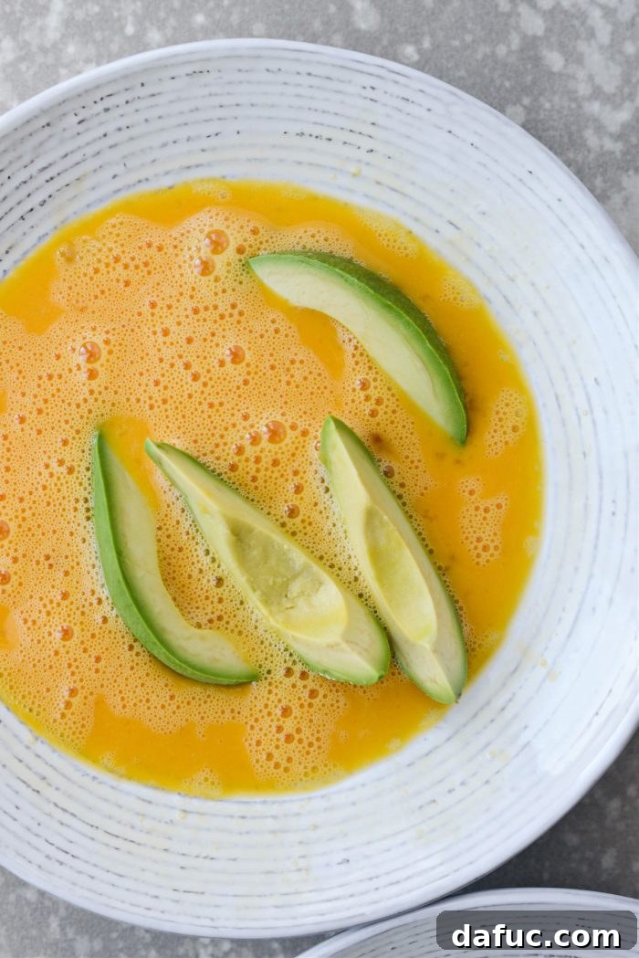 Dipping avocado wedges in beaten egg