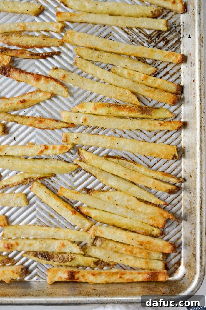 Golden Crispy Oven Fries 16 A baking sheet filled with perfectly golden brown and crispy oven baked French fries, fresh from the oven.