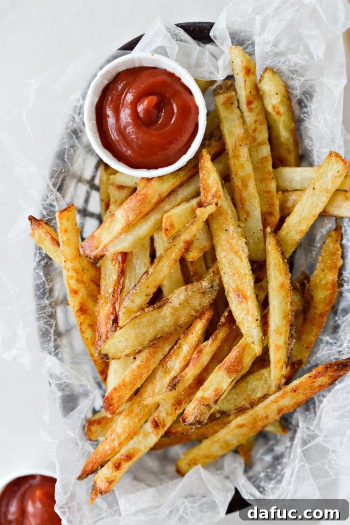 Golden Crispy Oven Fries 17 Assortment of crispy oven baked French fries served with various dipping sauces like ketchup and ranch.