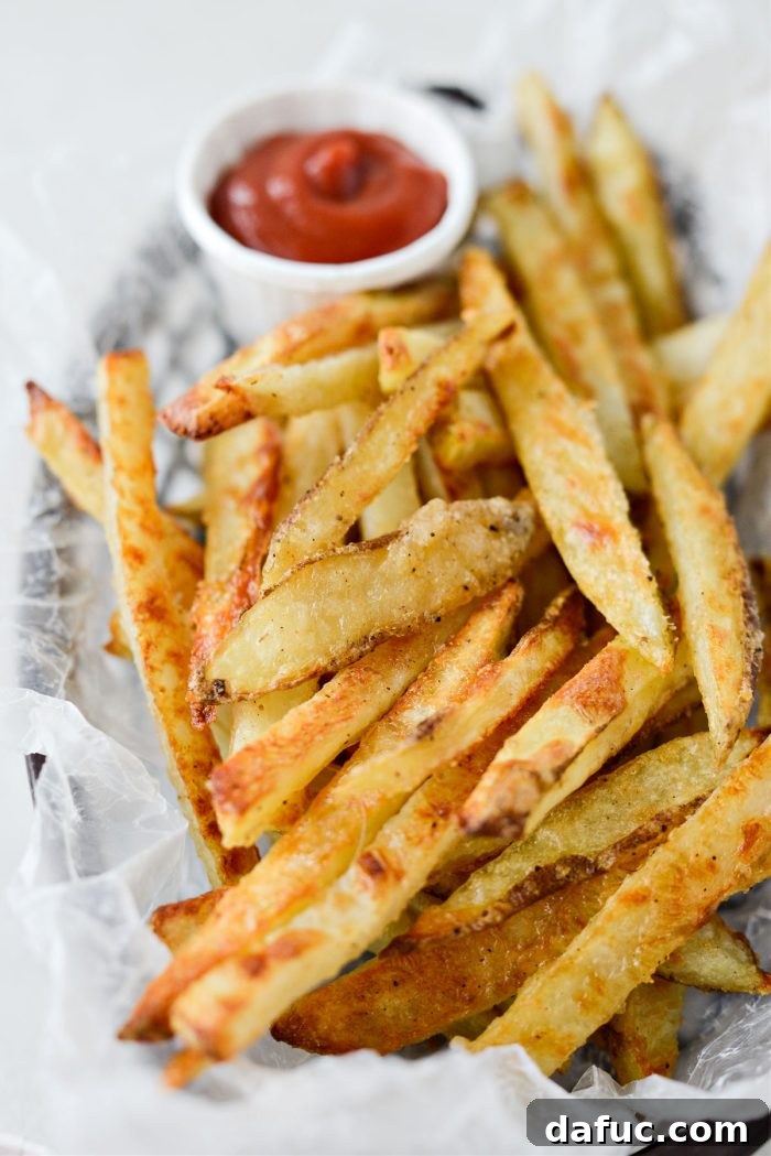 Golden Crispy Oven Fries 3 Two bowls of perfectly golden and seasoned oven baked French fries, ready for dipping.