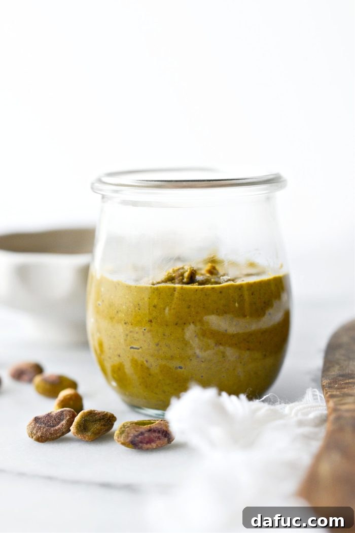 Freshly made homemade pistachio butter in a glass jar, ready to be enjoyed.