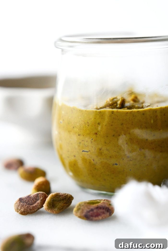 Homemade pistachio butter artfully spread on a plate, showcasing its vibrant green color.
