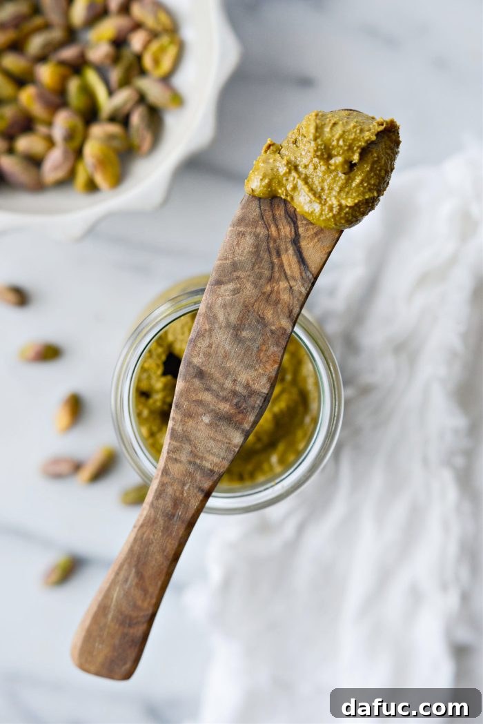 A collection of jars filled with homemade nut butters, including pistachio, showcasing variety.