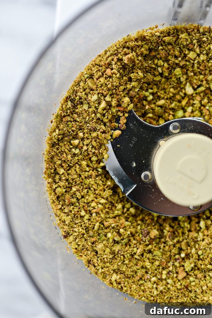 Pistachios in the food processor, freshly started and looking dry and crumbly.
