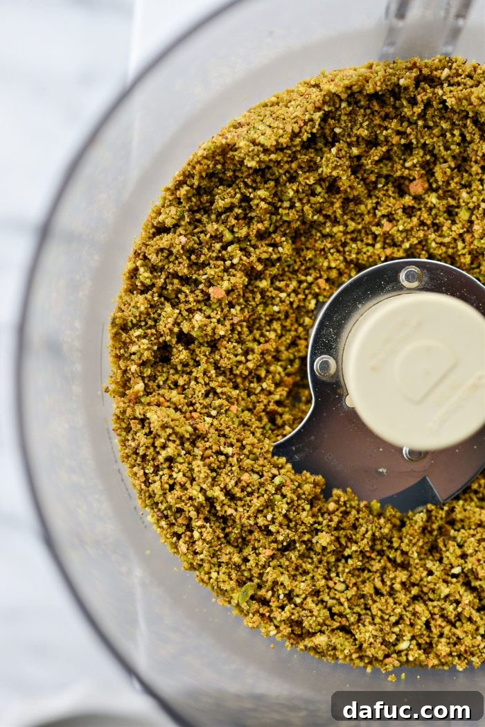 Pistachios processed further, now resembling a finer, dry crumbly texture.