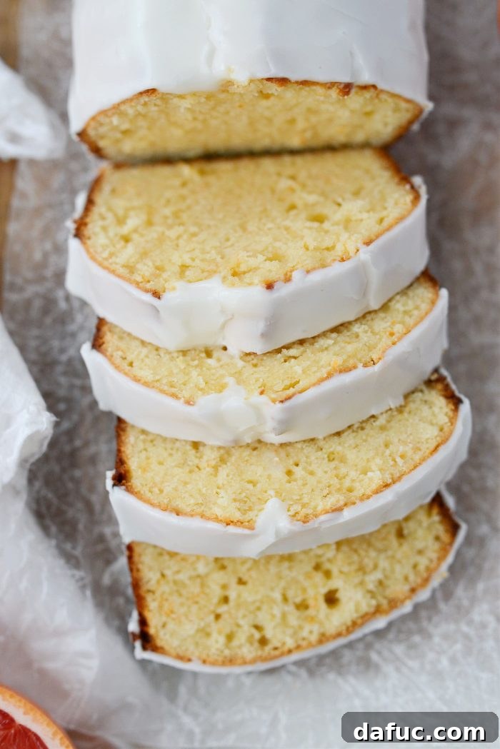 Creamy Grapefruit Zing Cake 2 Grapefruit Sour Cream Cake with a slice cut out, showing its moist texture and thick icing