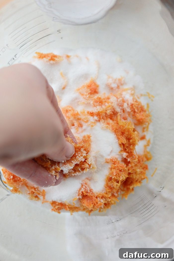 Creamy Grapefruit Zing Cake 7 Grapefruit zest being rubbed into granulated sugar with fingers in a large bowl