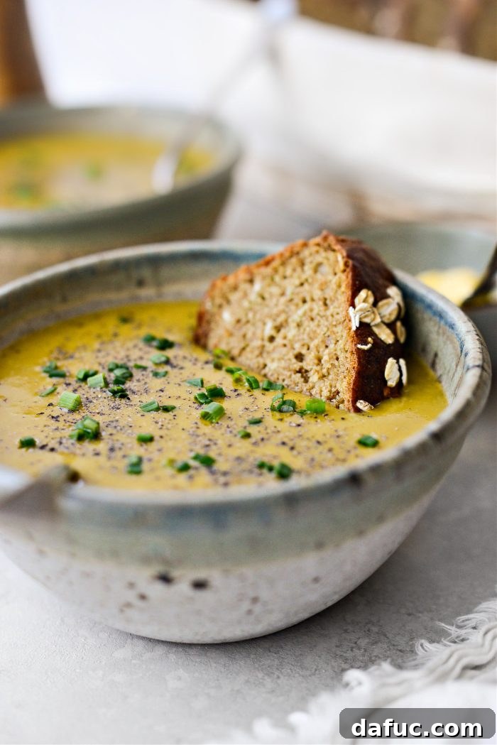 Hearty Irish Vegetable Soup 3 A steaming bowl of creamy Irish Vegetable Soup garnished with chives and black pepper, served with a slice of Irish brown bread.