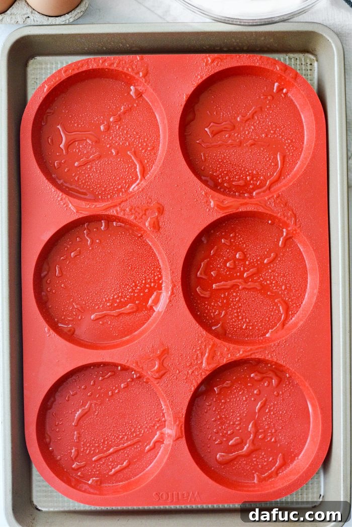 A silicone mold being sprayed with olive oil