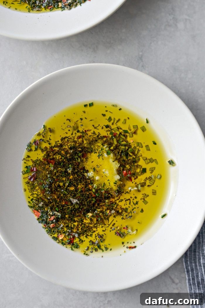 Garlic Herb Infused Dipping Oil 9 Plate with artfully arranged garlic, rosemary, and dried herbs ready for olive oil