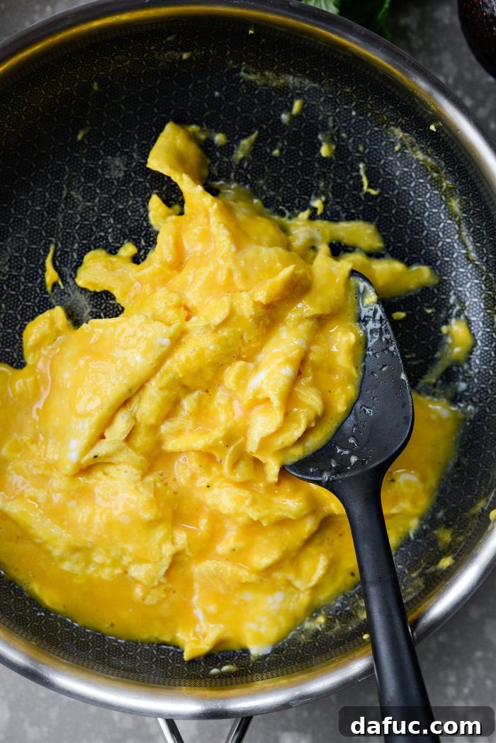 Scrambling eggs gently in a skillet with a rubber spatula