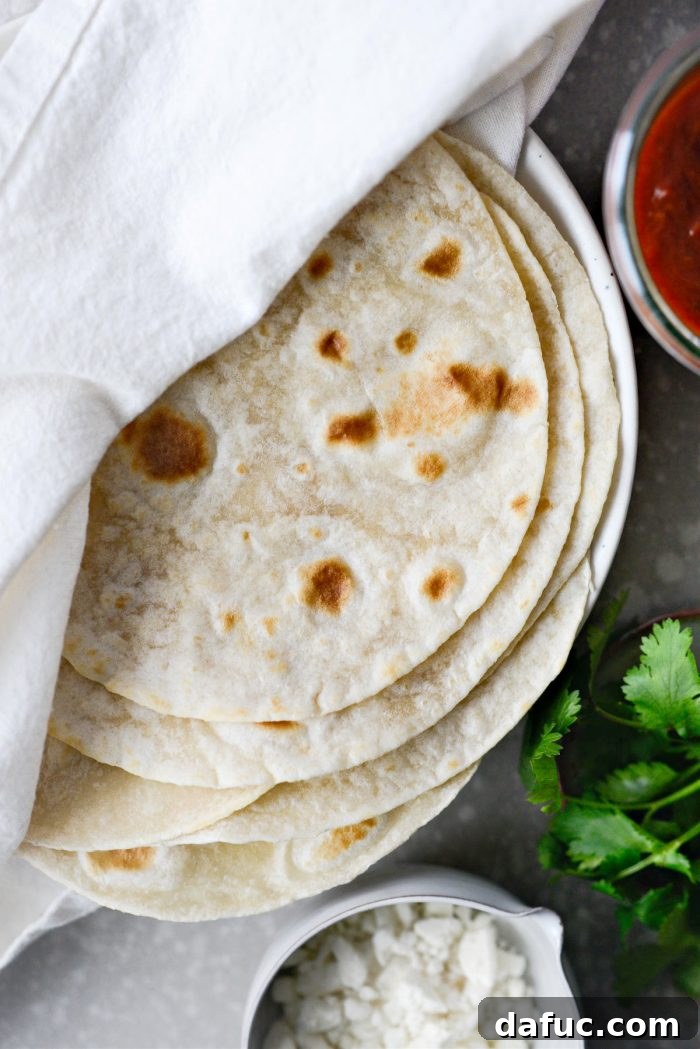 Warming fresh flour tortillas in a pan for breakfast tacos