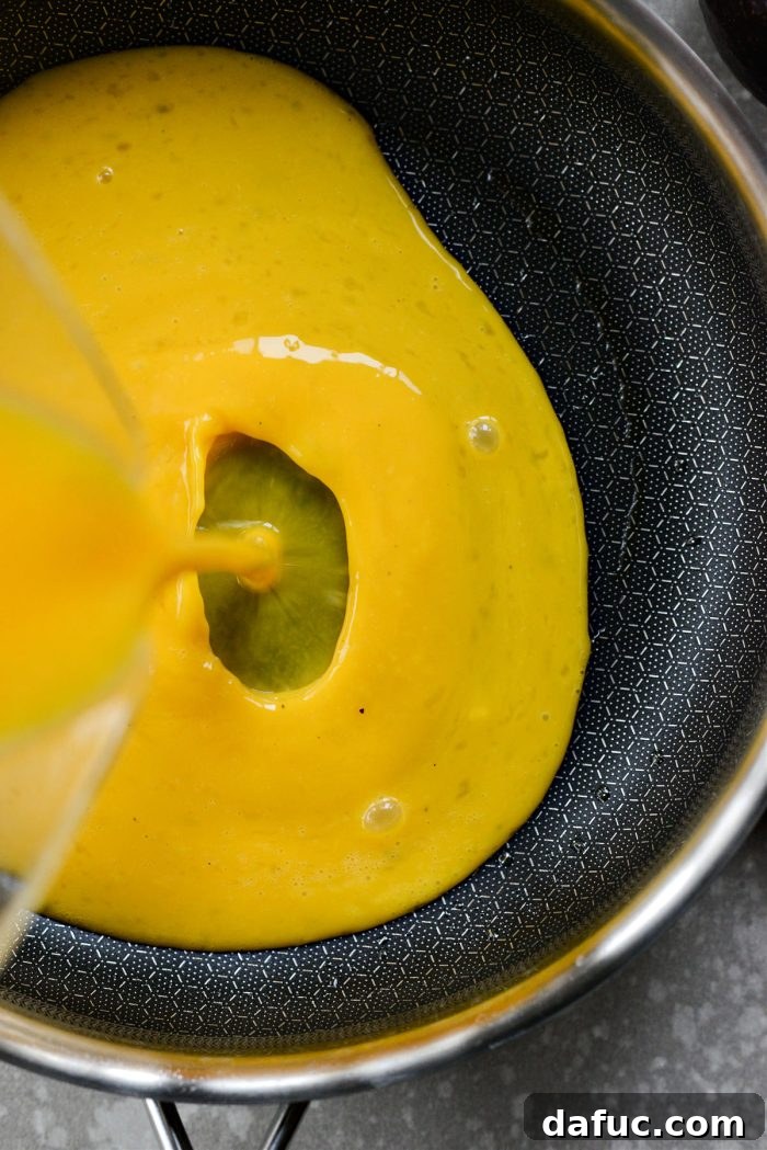 Pouring beaten eggs into a preheated nonstick skillet
