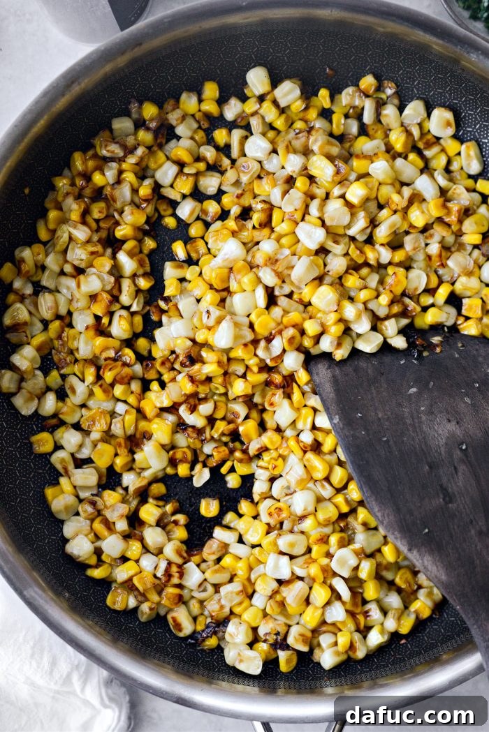 Zesty Mexican Street Corn Dip 6 Charred corn kernels in a skillet with golden brown spots