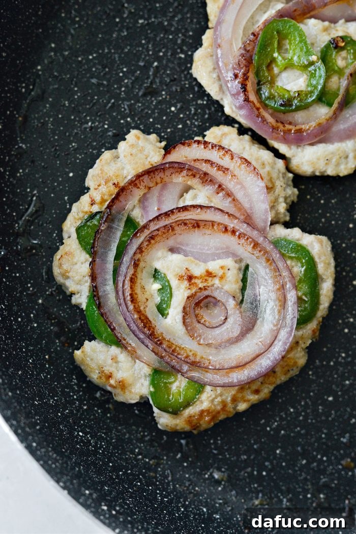 Cooking chicken smash burgers in a skillet