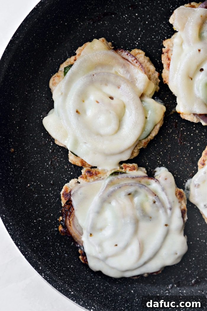 Cheese melting on chicken smash burgers
