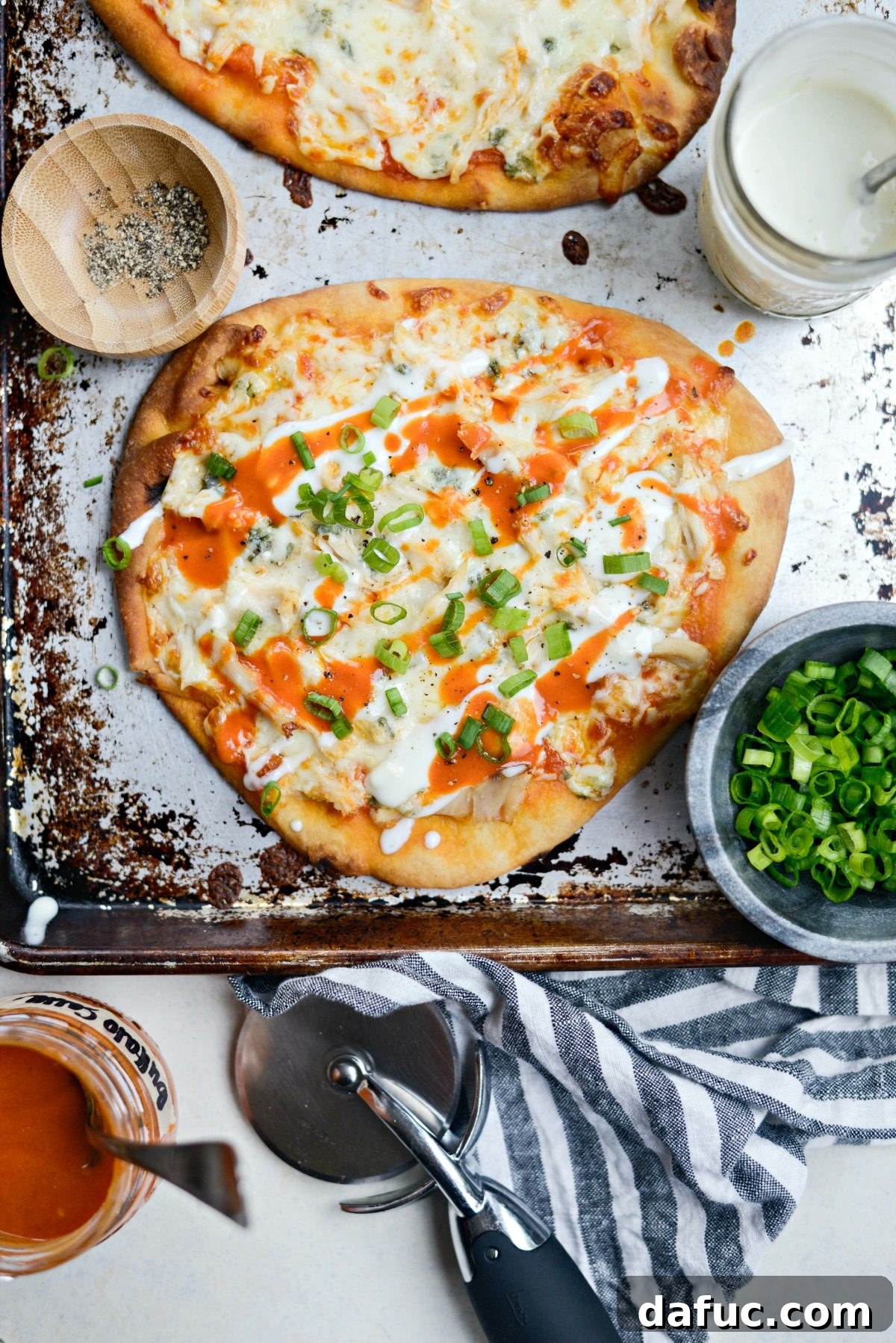 Delicious Buffalo Chicken Flatbread Pizzas on a baking sheet, ready to serve.