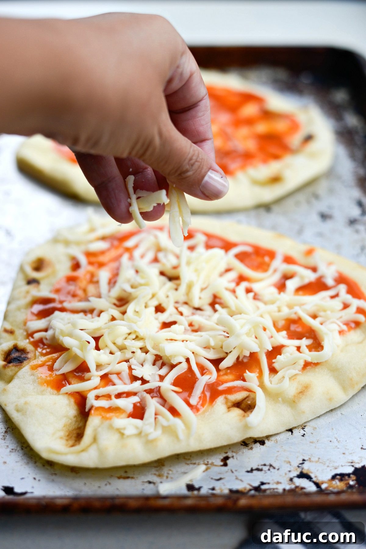 Topping buffalo sauce-covered naan with shredded Monterey Jack cheese.