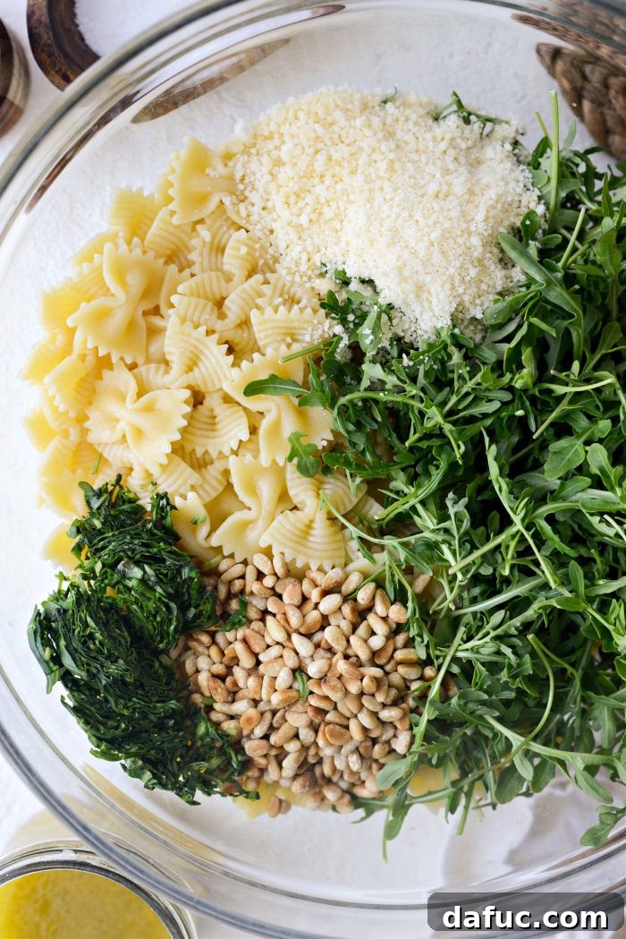 Bright Lemon Basil Parmesan Pasta Salad 11 Adding prepared pasta salad ingredients to a large mixing bowl