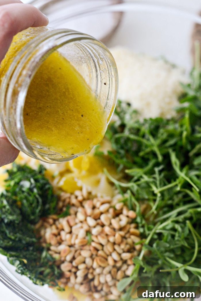 Bright Lemon Basil Parmesan Pasta Salad 12 Pouring the lemon vinaigrette over the pasta salad ingredients