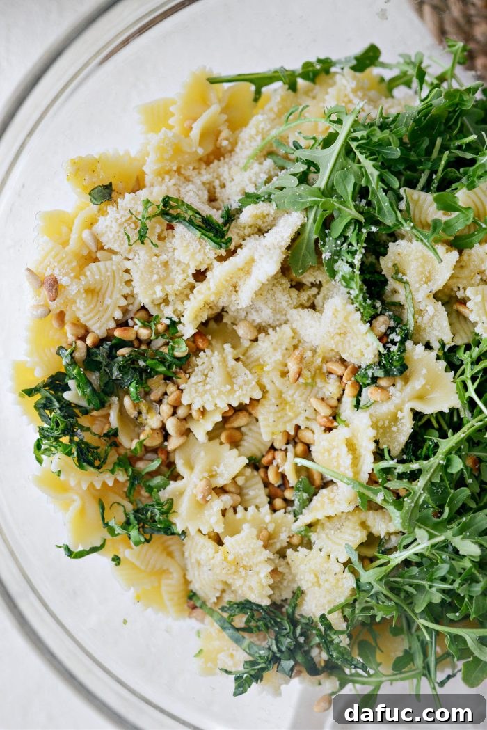 Bright Lemon Basil Parmesan Pasta Salad 13 Tossing the pasta salad ingredients with dressing