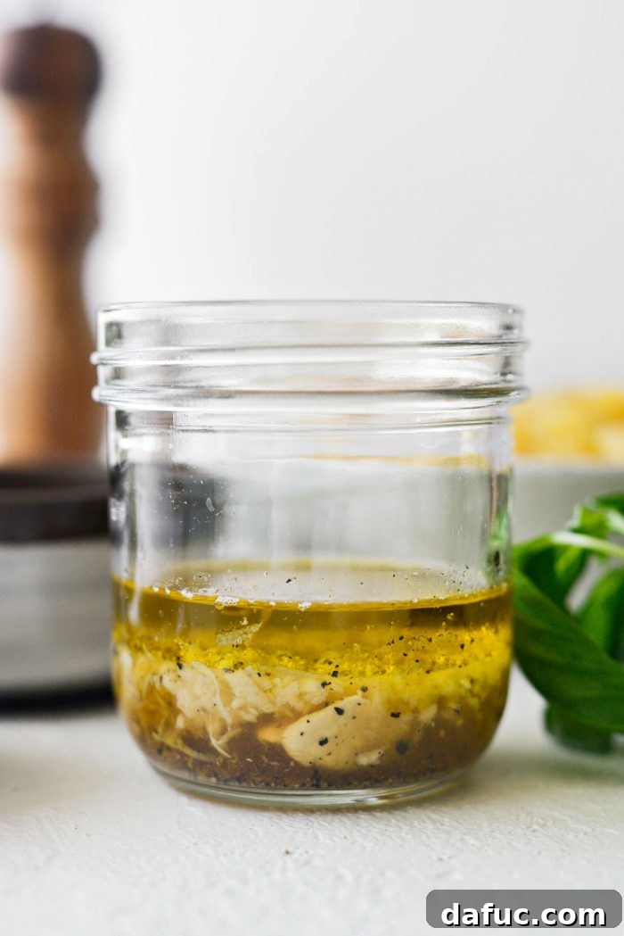 Bright Lemon Basil Parmesan Pasta Salad 5 Vinaigrette ingredients in a glass jar, ready to be shaken