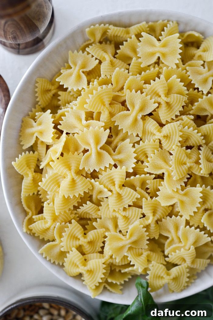 Bright Lemon Basil Parmesan Pasta Salad 8 Uncooked bowtie pasta in a bowl, ready for cooking