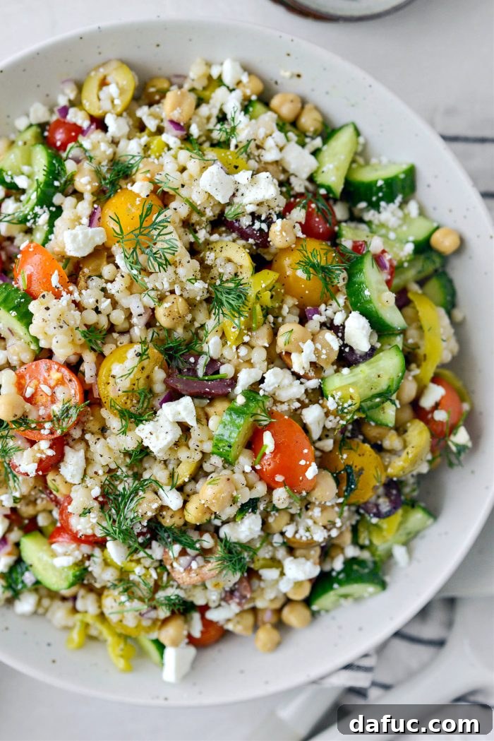 Vibrant Mediterranean Couscous Salad 2 A vibrant Greek Couscous Salad in a large serving bowl, with fresh ingredients visible.