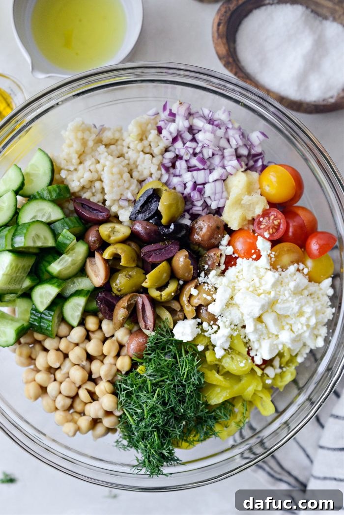 Vibrant Mediterranean Couscous Salad 7 Adding chickpeas and other ingredients to the couscous bowl.