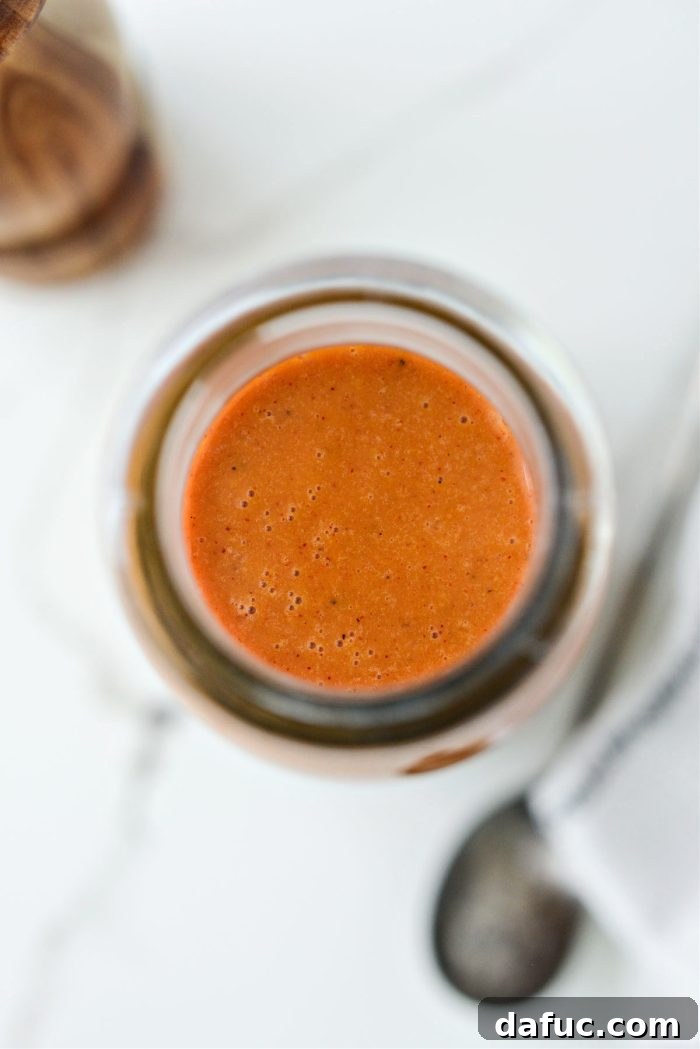 Tangy Homemade Catalina Vinaigrette 3 Homemade Catalina Dressing poured over a fresh salad, showcasing its rich orange color.
