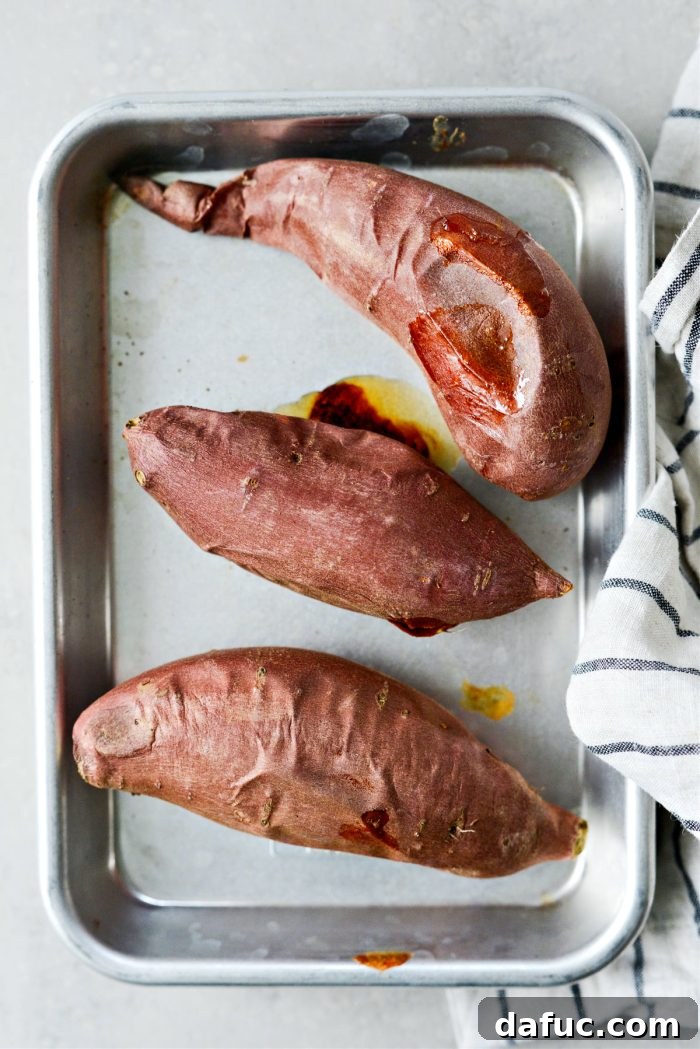 Velvety Sweet Potato Puree 5 Baked sweet potatoes on a baking sheet, golden and tender.