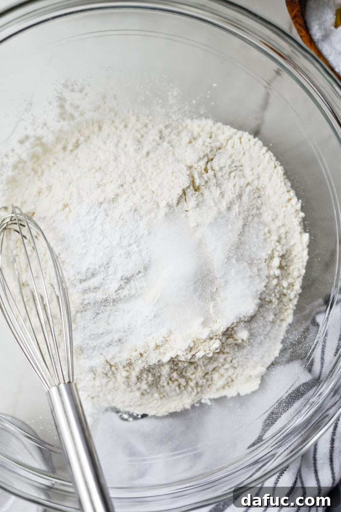 Effortlessly Fluffy Drop Biscuits 4 Measuring and adding dry ingredients for drop biscuits into a mixing bowl.