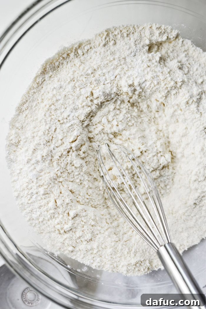 Effortlessly Fluffy Drop Biscuits 5 Whisking dry ingredients together in a mixing bowl for biscuit dough.