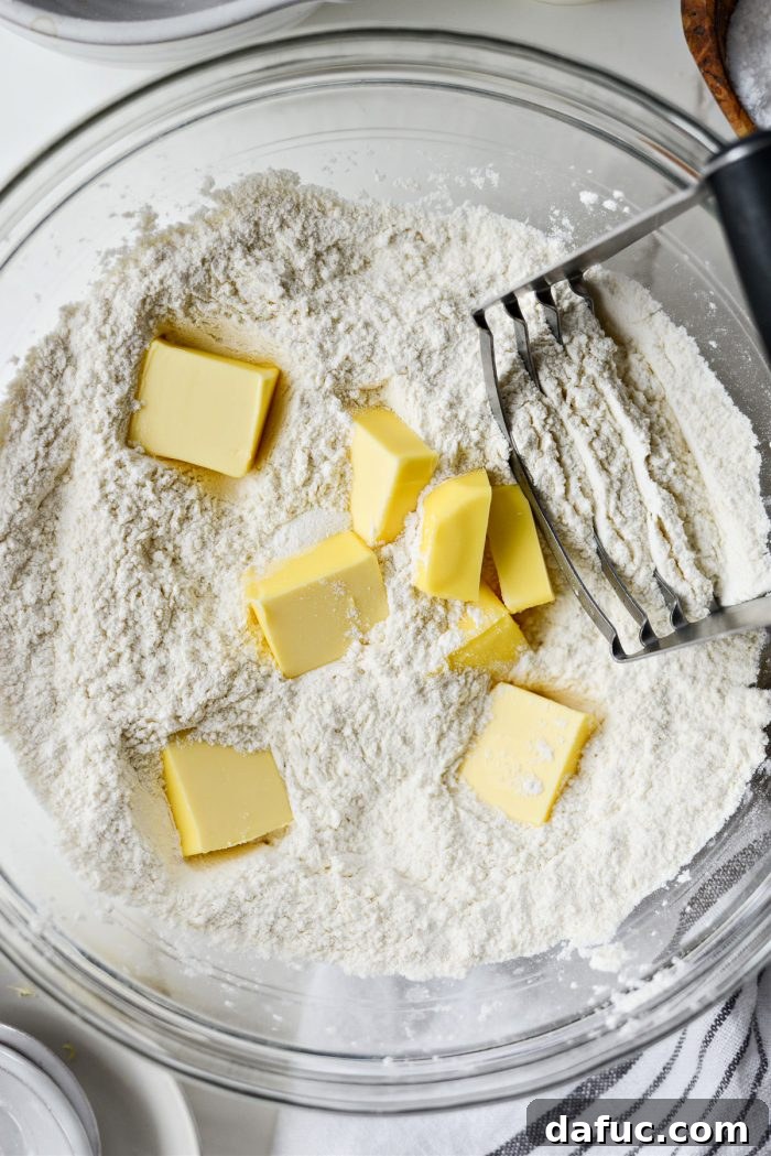 Effortlessly Fluffy Drop Biscuits 6 Adding cold, cubed butter into the dry biscuit ingredients.