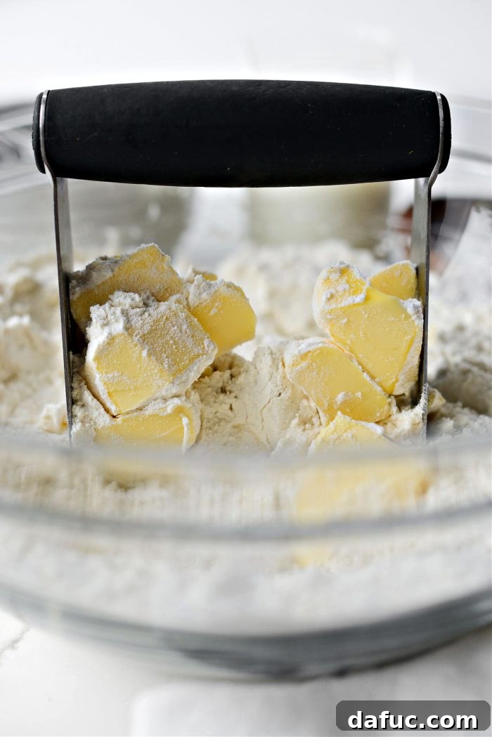 Effortlessly Fluffy Drop Biscuits 7 Cutting cold butter into dry biscuit ingredients using a pastry blender.
