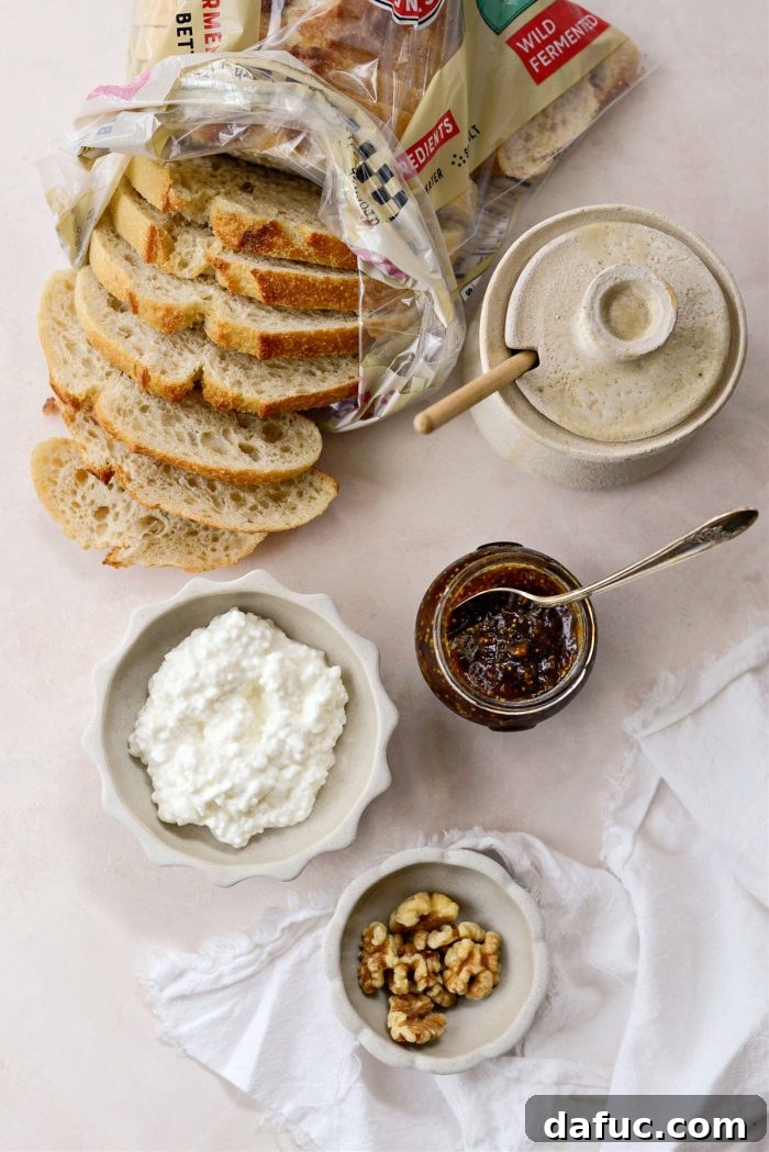 Honeyed Fig & Creamy Cottage Cheese Toast 4 All ingredients laid out: sourdough bread, cottage cheese, fig jam, honey, and walnuts.
