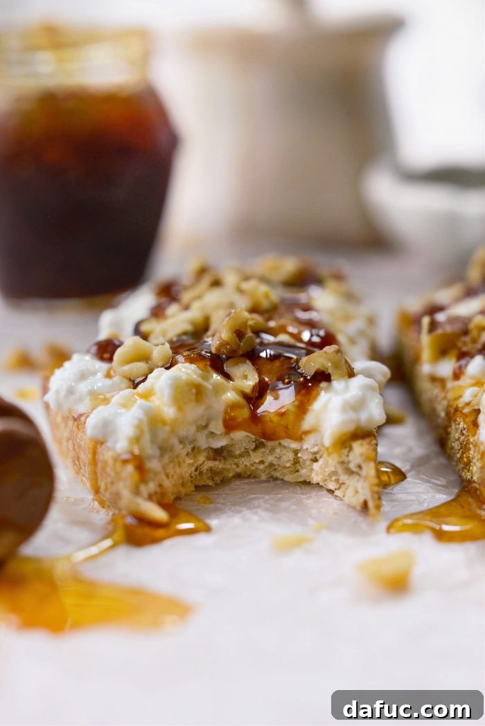 Honeyed Fig & Creamy Cottage Cheese Toast 9 A person taking a bite out of the Honey Fig Jam and Cottage Cheese Toast, showing the layers.