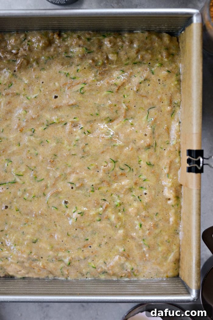 Lush Zucchini Cake with Cream Cheese Frosting 10 Pouring zucchini cake batter into the prepared baking pan