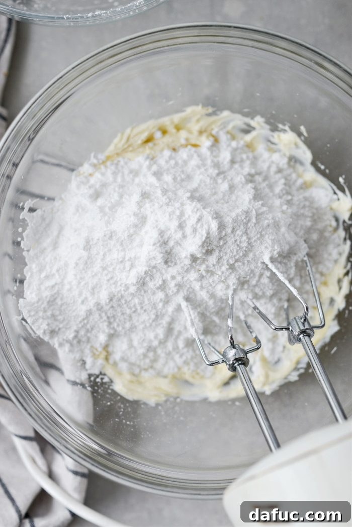 Lush Zucchini Cake with Cream Cheese Frosting 14 Adding sifted powdered sugar to the cream cheese mixture