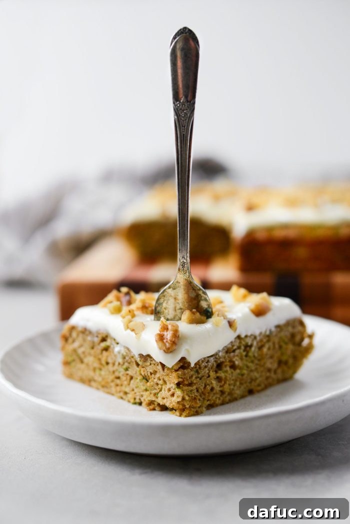 Lush Zucchini Cake with Cream Cheese Frosting 3 Two slices of Zucchini Cake with Cream Cheese Frosting on a white plate