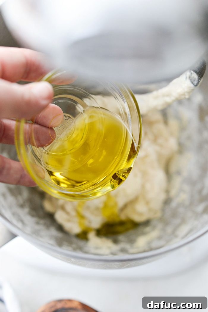Fluffy Focaccia Pizza Dough Recipe 9 Adding olive oil to the focaccia dough in a stand mixer.