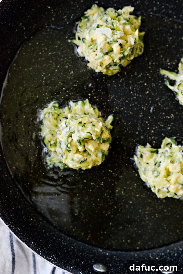 Crispy Zucchini Corn Fritters 11 Zucchini Corn Fritters frying in a hot skillet